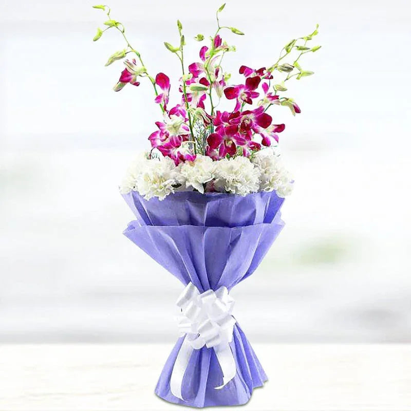 Bouquet of flowers wrapped in purple paper with a white bow on a light background