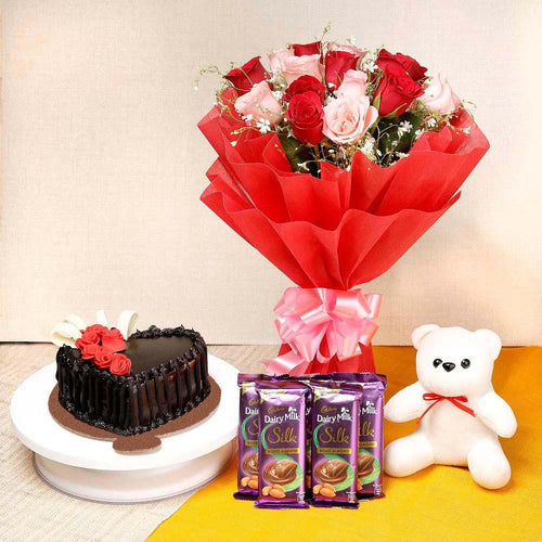 Bouquet of red and pink roses, chocolate cake, Dairy Milk Silk chocolates, and a white teddy bear 