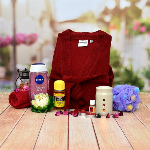 Red robe with Nivea and body oil products on a wooden surface with a blurred garden background.
