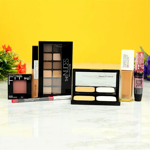 Makeup products including palettes and a bottle on a white surface with a yellow background