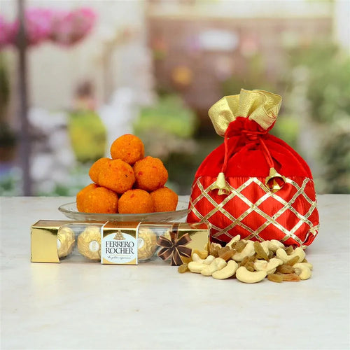 Ferrero Rocher chocolate, red and gold gift bag, and assorted nuts on a table with a blurred floral background.