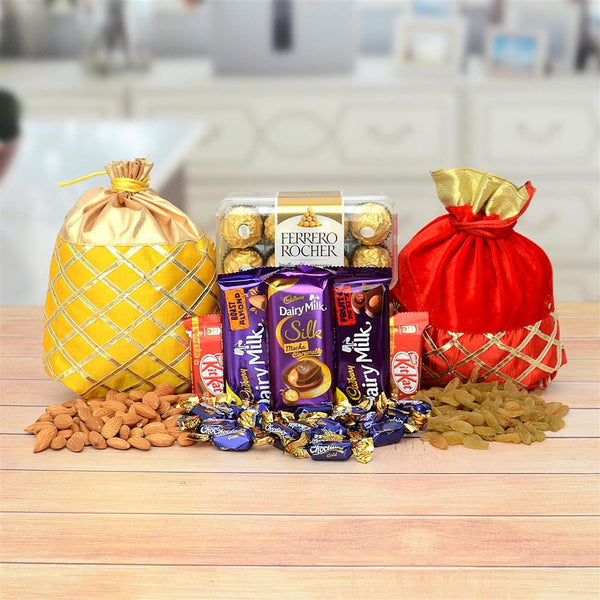 Assorted chocolates and dry fruits with decorative bags on a wooden table.