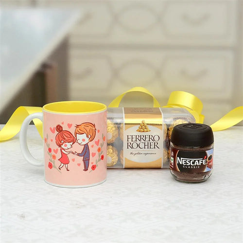 Mug with cartoon design, Ferrero Rocher chocolate, and Nescafe jar on a light surface.
