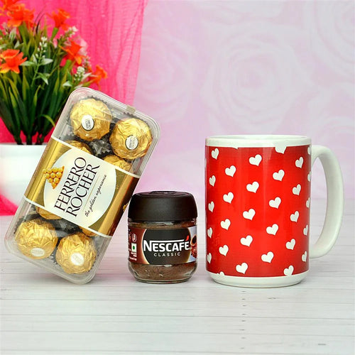 Ferrero Rocher chocolates, Nescafe coffee, and a red mug with heart patterns on a pink background