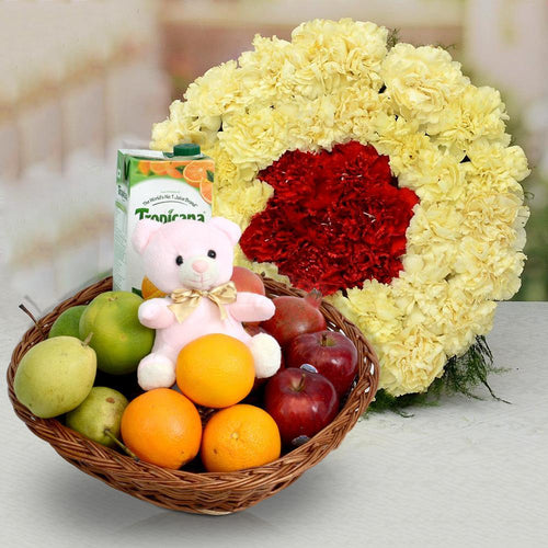 Basket of fruits with a plush toy, juice box, and yellow flowers with a red center 