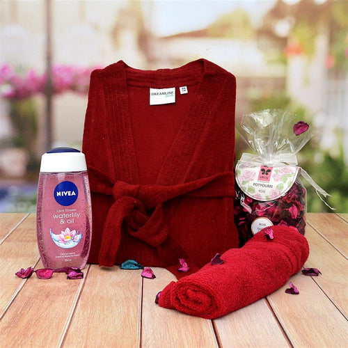 Red robe, Nivea bottle, and wrapped gift on a wooden surface 