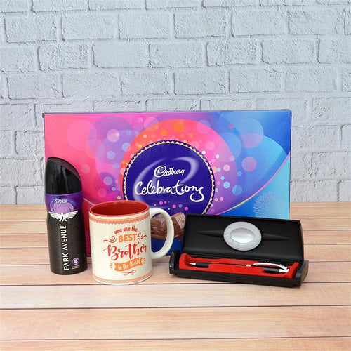 Gift set with mug, chocolate, and Pen Then Brother Mug Perfume items on a wooden surface with a brick wall background.
