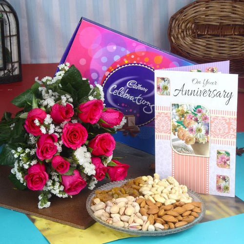 Bouquet of pink roses, Cadbury chocolate, and a 'On Your Anniversary' card dry fruits
