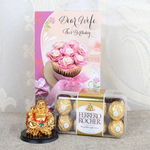 Packaged Ferrero Rocher chocolates, a small golden Buddha statue, and a birthday card with a pink cupcake design.
