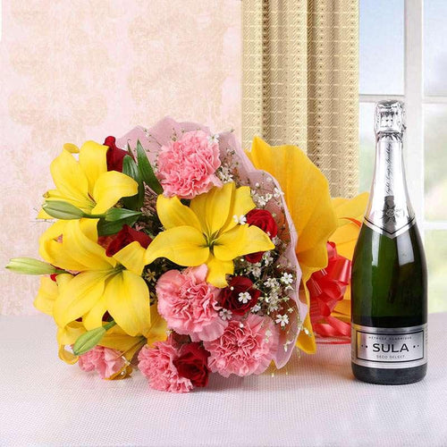 Bouquet of yellow lilies and pink carnations with a bottle of Sula sparkling wine 