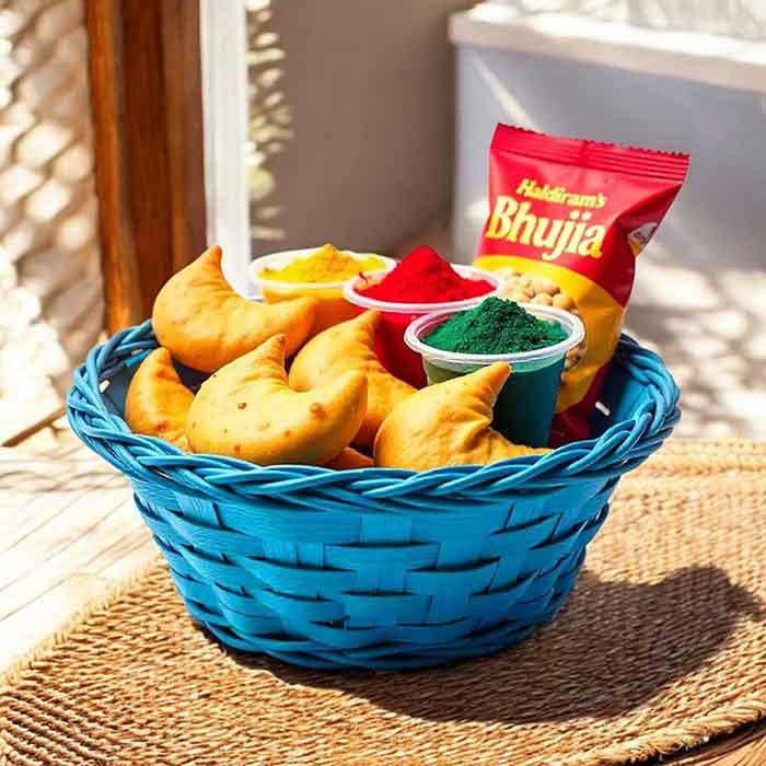 Blue basket with gujiya sweets, colored powder for Holi, and a pack of bhujia snack
