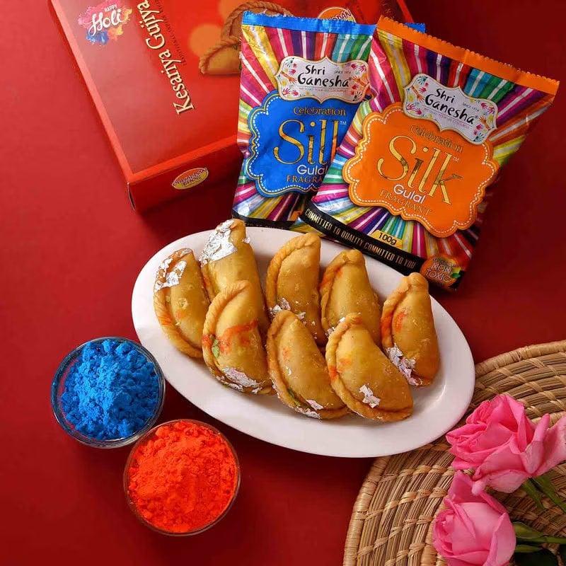 Plate of fried snacks with colorful gulal and Shri Ganeshila packets on a red background