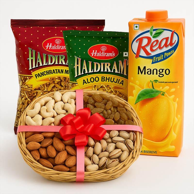 Gift hamper with assorted dry fruits in a basket, Haldiram snacks, and mango juice carton