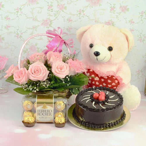 Teddy bear, chocolate cake, and bouquet of pink roses with Ferrero Rocher chocolates on a floral background.