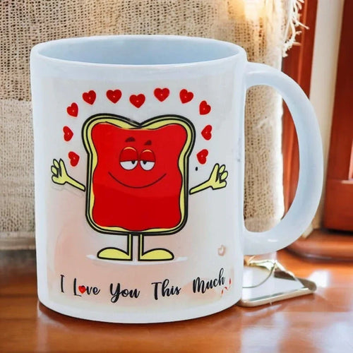 Mug with cartoon character and 'I Love You This Much' text on a wooden surface.