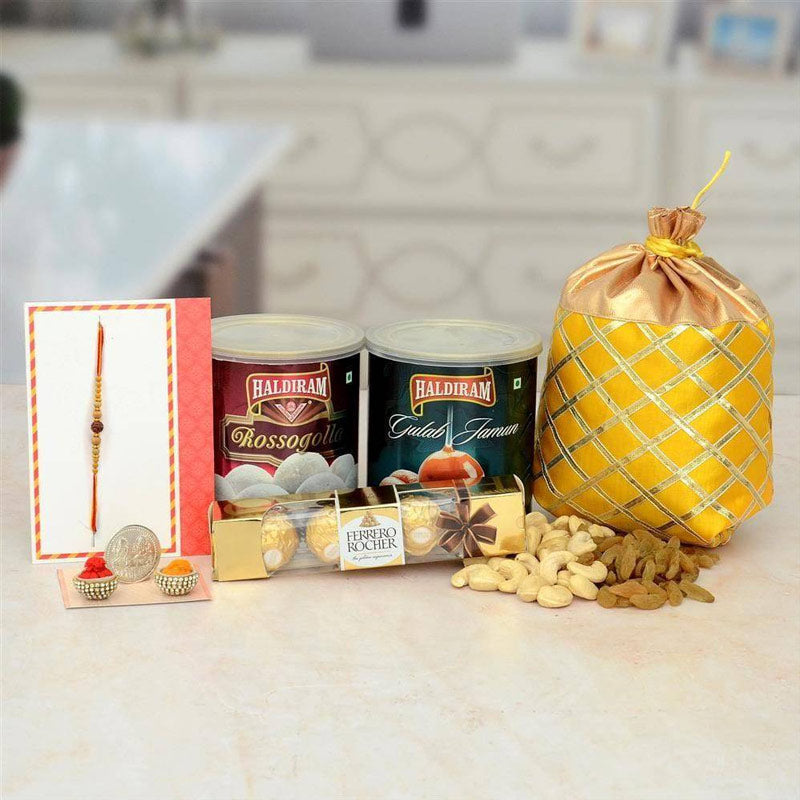 Gourmet gift set with Haldiram products and a yellow fabric bag on a kitchen counter.