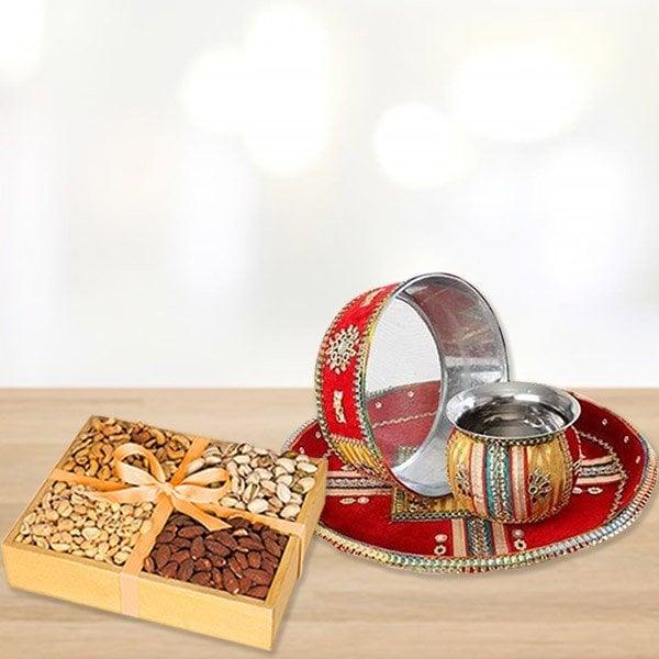 Box of assorted nuts on a wooden surface with a decorative tray and lamp 