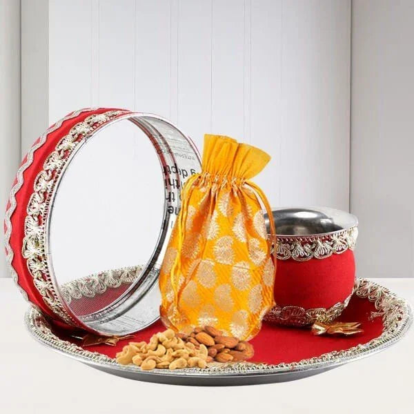 Decorative tray with silver bowls, a red and gold bag, and nuts 