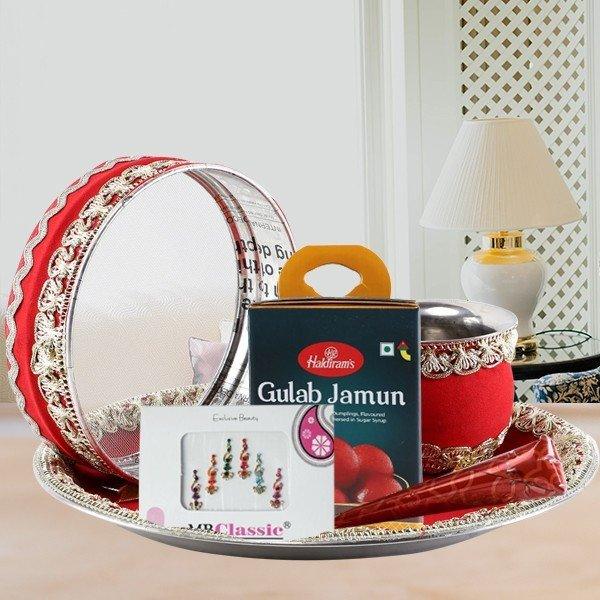 Tray with Gulab Jamun box, red and silver bangles, and a card 
