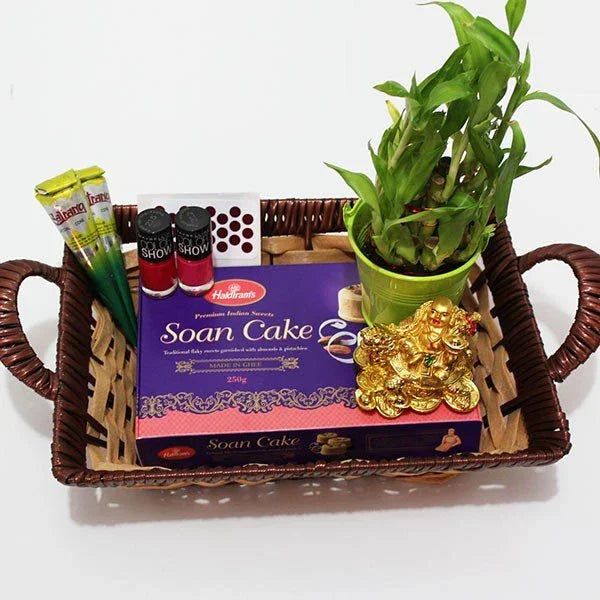 Basket with Soan Cake, snacks, a plant, and gold buddha on a white background
