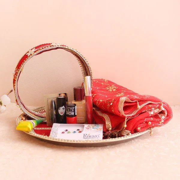 Decorative tray with a mirror, makeup items, and a red saree 