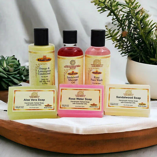 Collection of Kama Ayurveda skincare products on a wooden tray with plants in the background.