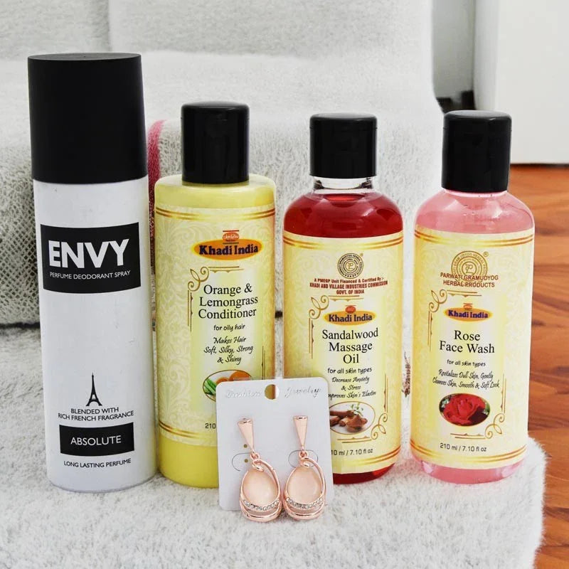 Collection of beauty products including a perfume, conditioner, massage oil, and face wash with a card displaying earrings.