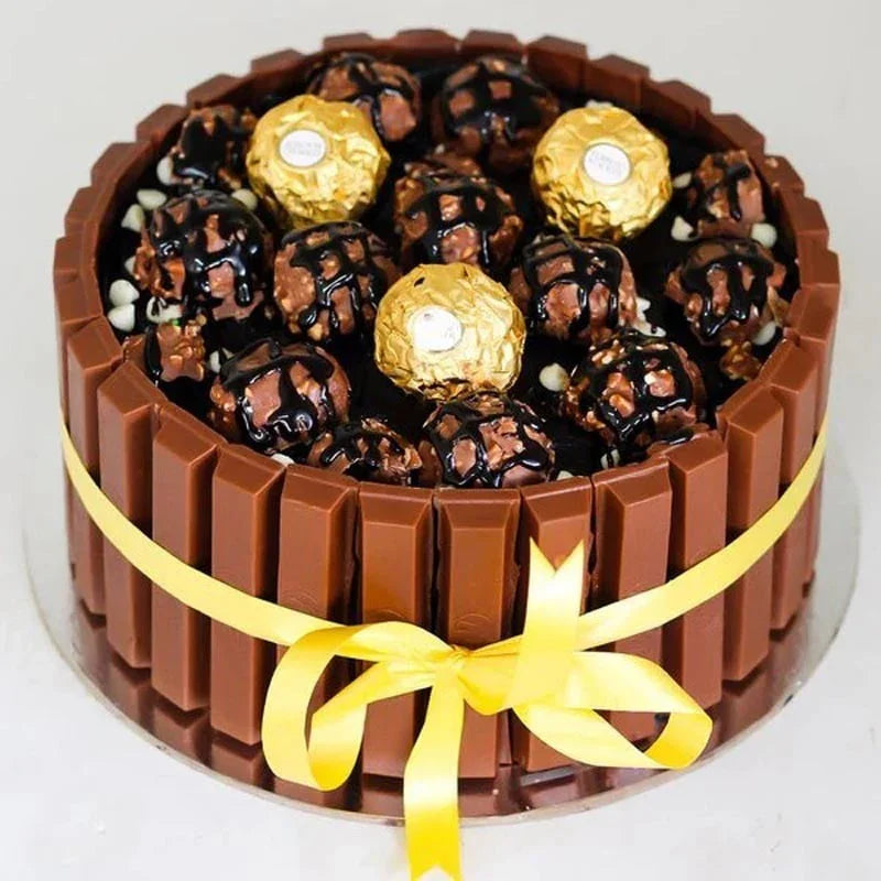 Chocolate candy bar cake with gold Ferrero Rocher chocolates and KitKat bars on a white background