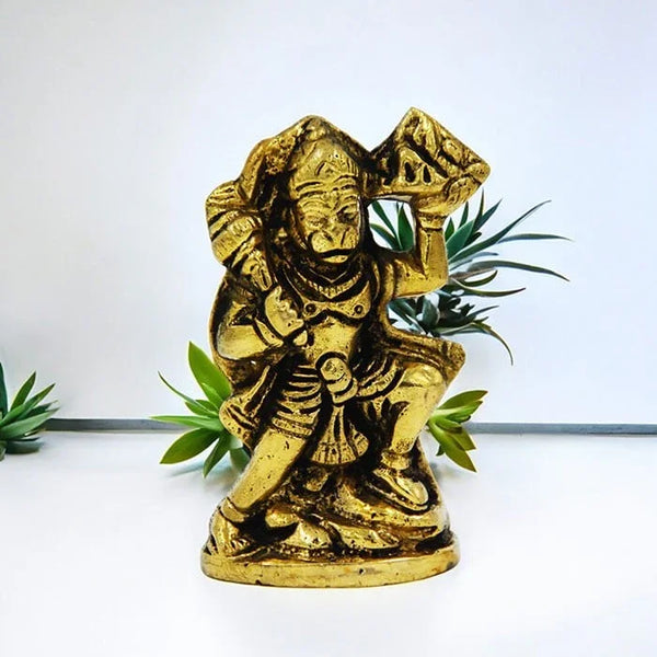 Gold statue of a deity with green leaves on a white background