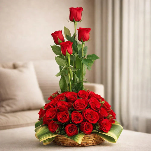 Bouquet of red roses in a woven basket on a light-colored surface with a neutral background