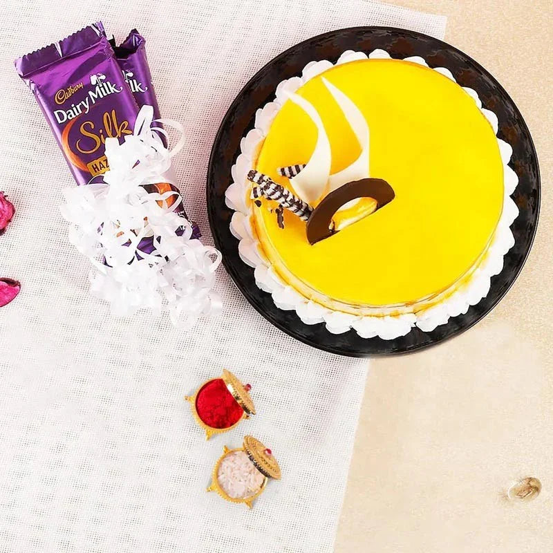 Yellow cake with decorative elements on a white tablecloth, featuring Cadbury Dairy Milk Silk chocolate bars.