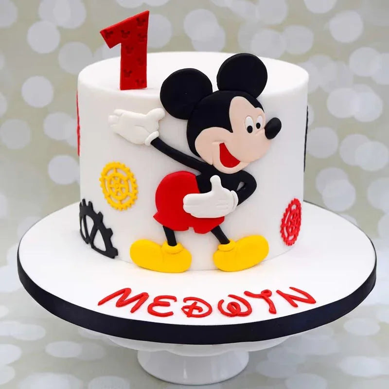 Cake with Mickey Mouse design and '1' topper on a white background