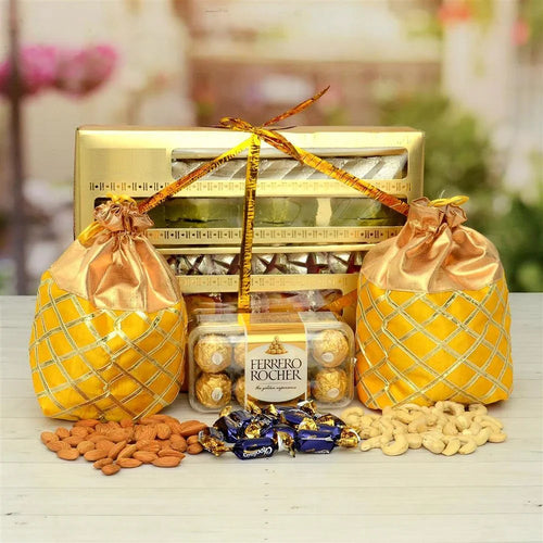 Gourmet gift set with Ferrero Rocher, chocolates, and nuts on a wooden surface.