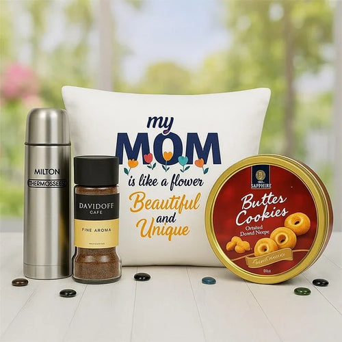 Gift set with thermos, coffee, pillow, and cookies on a blurred nature background