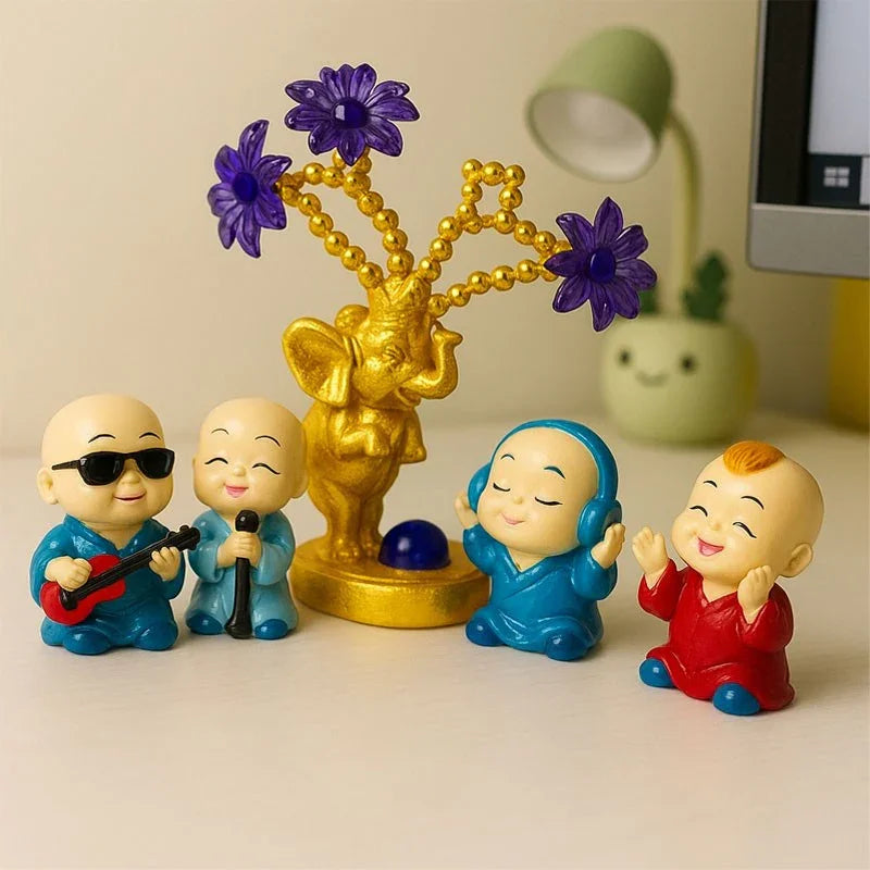 Colorful figurines of four monks with a golden elephant and purple flowers on a beige surface.