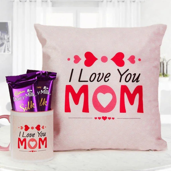 Pink pillow with 'I Love You Mom' text, Cadbury Dairy Milk Silk chocolate packets, and a mug with similar text on a white background.