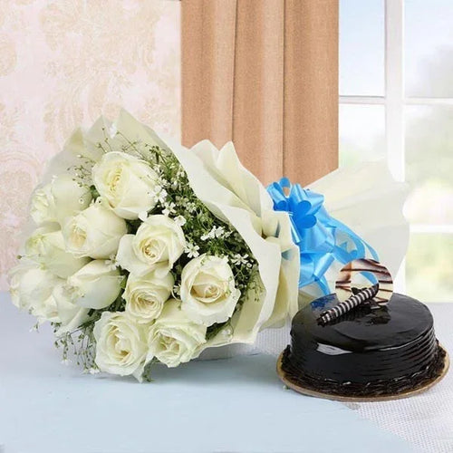 Bouquet of white roses with blue ribbon and chocolate cake on a table, gift arrangement