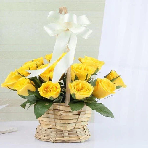 Basket of yellow roses with green leaves and white ribbon, 