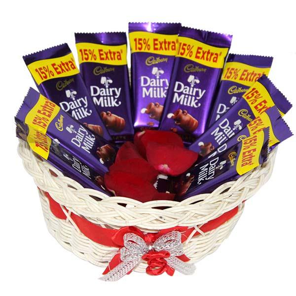 Gift basket with Dairy Milk chocolate bars and red rose petals, ideal for gifting occasions