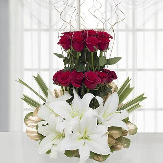 Elegant floral arrangement with red roses and white lilies, perfect for gifting occasions.