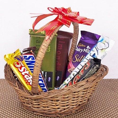 Chocolate gift basket with assorted Cadbury bars and a ribbon, ideal for birthdays and celebrations.