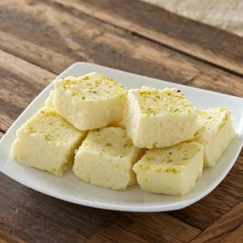 White plate with pieces of white dessert on a wooden surface