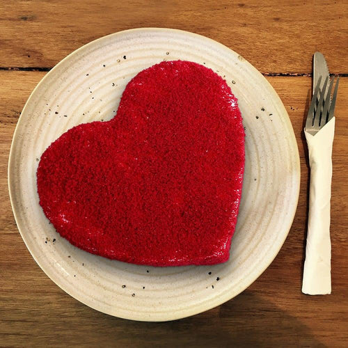 Heart-shaped red cake on a white plate 