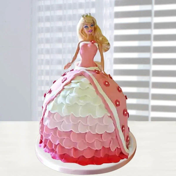 Cake designed to look like a Barbie doll with a pink dress against a white background