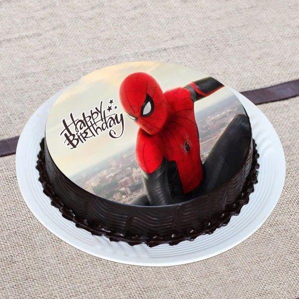 Chocolate cake with a Spider-Man figure and 'Happy Birthday' text on a textured surface