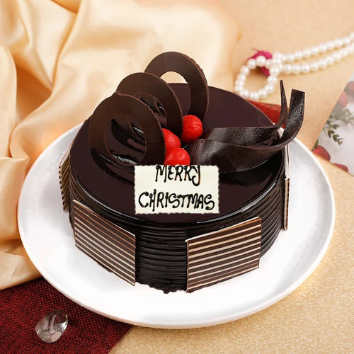 Chocolate cake with 'Merry Christmas' decoration on a white plate