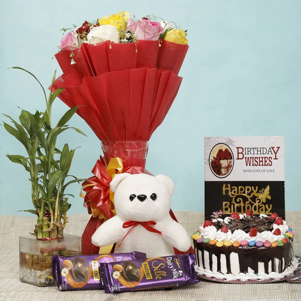 Bouquet of flowers, teddy bear, birthday cake, and chocolate bars on a table