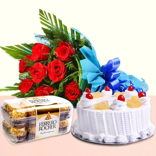 Bouquet of red roses, Ferrero Rocher chocolates, and a white cake with fruit 