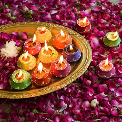 Colorful decorative diyas on a brass plate with rose petals, festive 