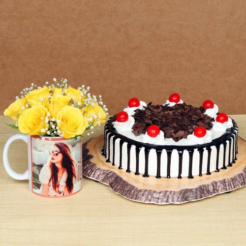 Black forest cake with red cherries and a mug with yellow flowers on a brown background